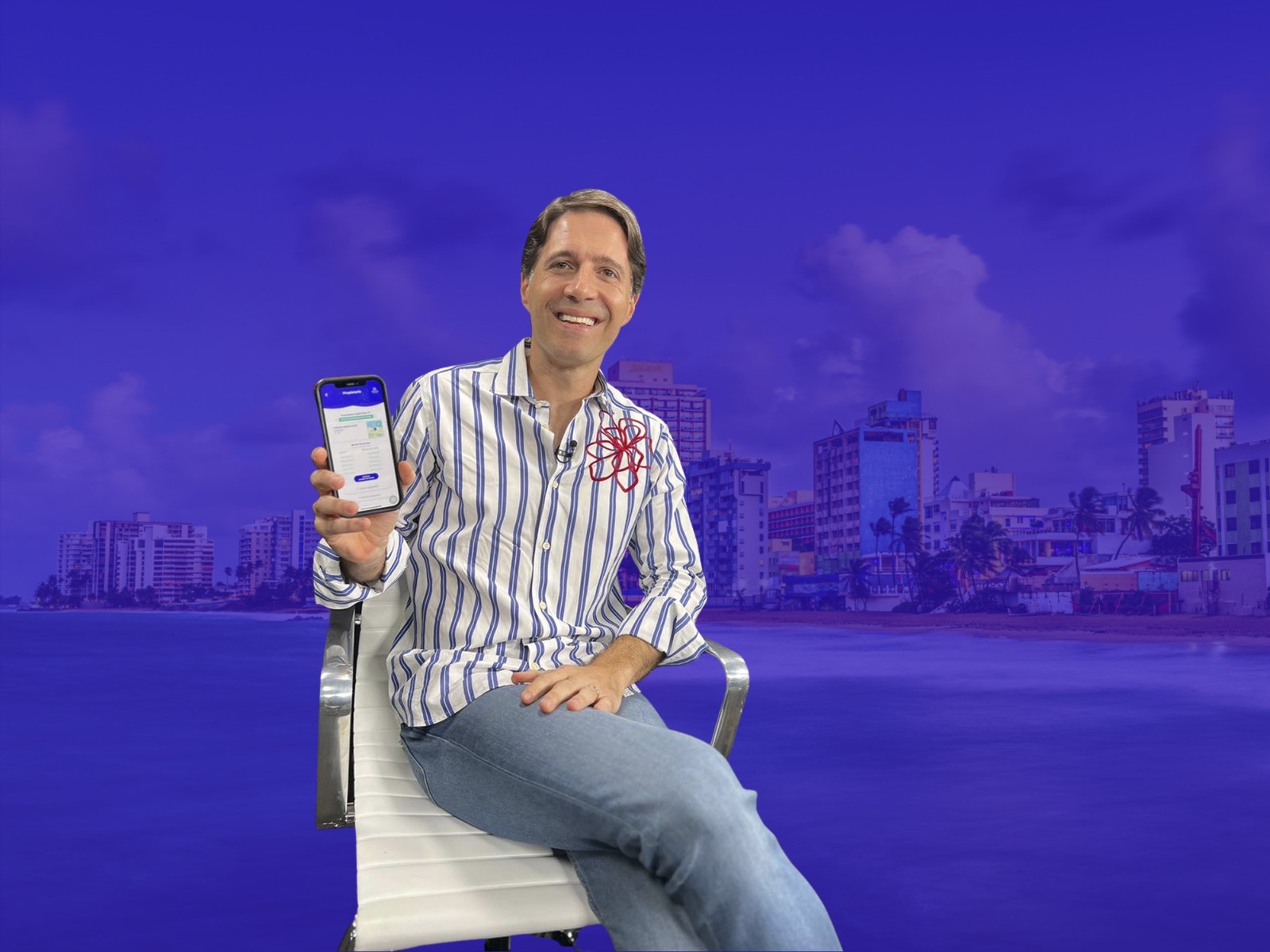 Giancarlo González Ascar sentado, mostrando la app de Urbital en su celular