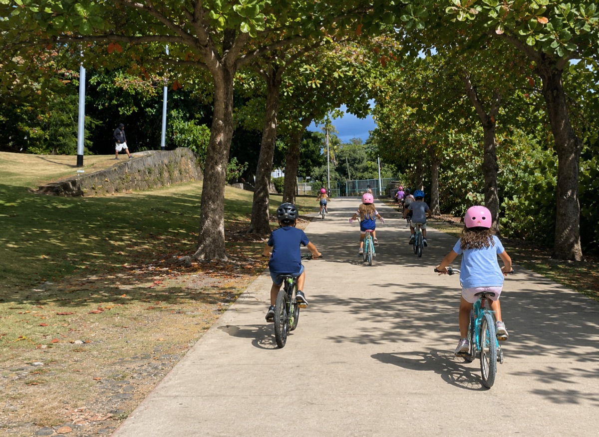Niños en bicicleta bajo árboles, en la zona donde proponen el estacionamiento